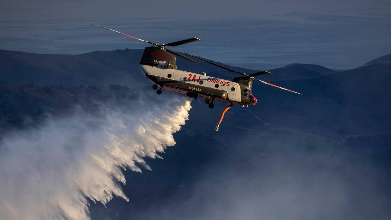 GOLETA, CA - OCTOBER 13: A firefighting helicopter makes a water drop as the Alisal Fire burns on October 13, 2021 near Goleta, California.