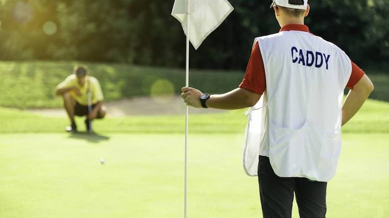 Golf caddie holding a flag