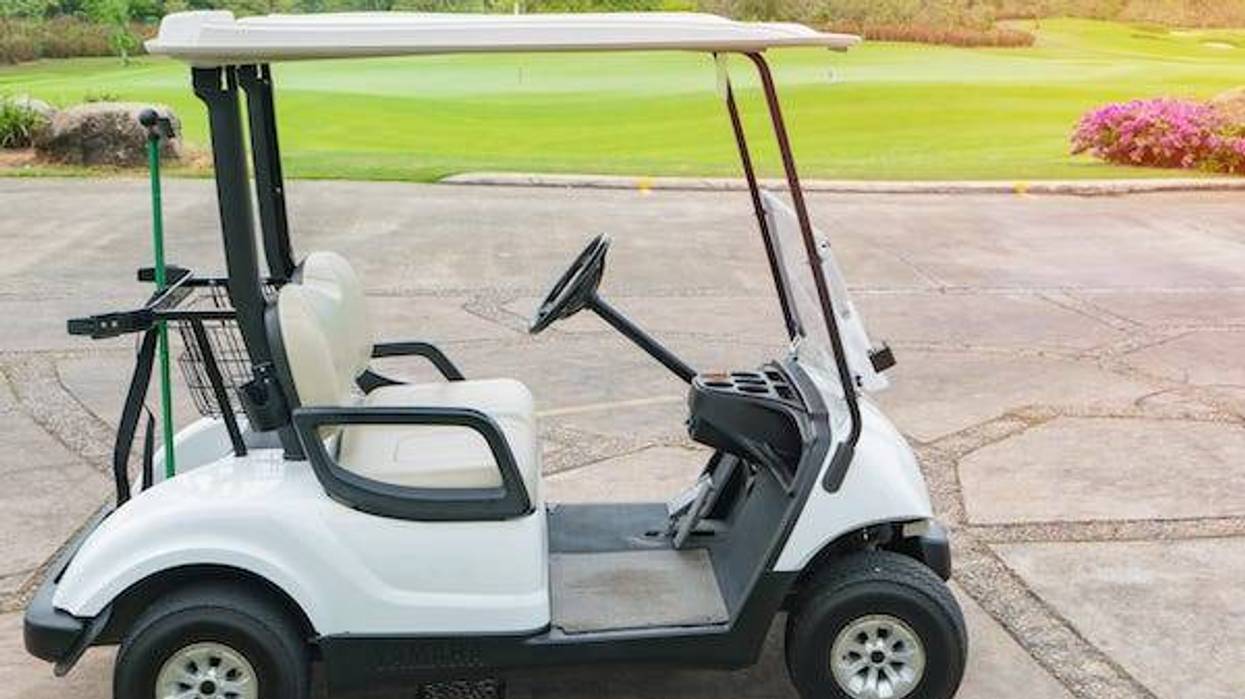 Golf cart parked in front of a golf course
