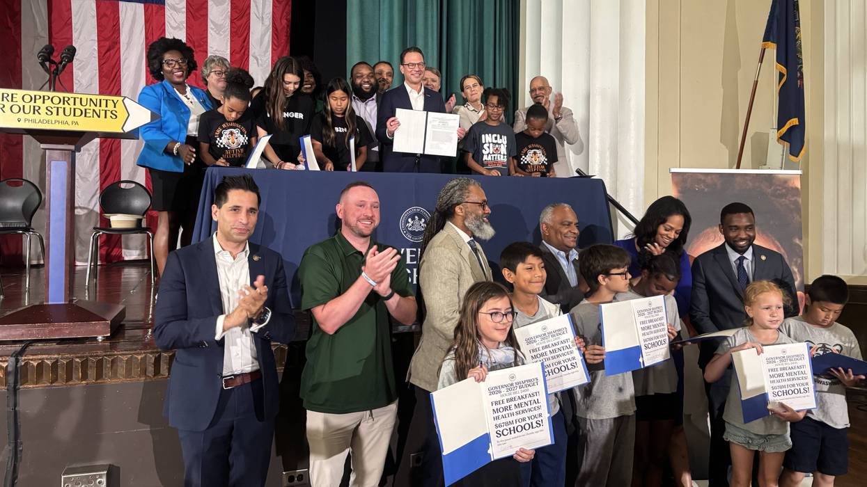 Gov. Josh Shapiro holds up the signed state budget at a ceremonial signing Tuesday, July 14 at Vare-Washington Elementary School in South Philadelphia.