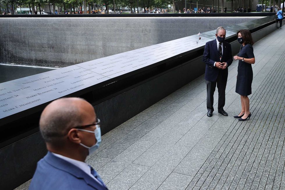 Gov. Kathy Hochul and former Mayor Mike Bloomberg prepare to talk to the press after laying flowers at the edge of the south memorial pool of the 9/11 Memorial on September 08, 2021
