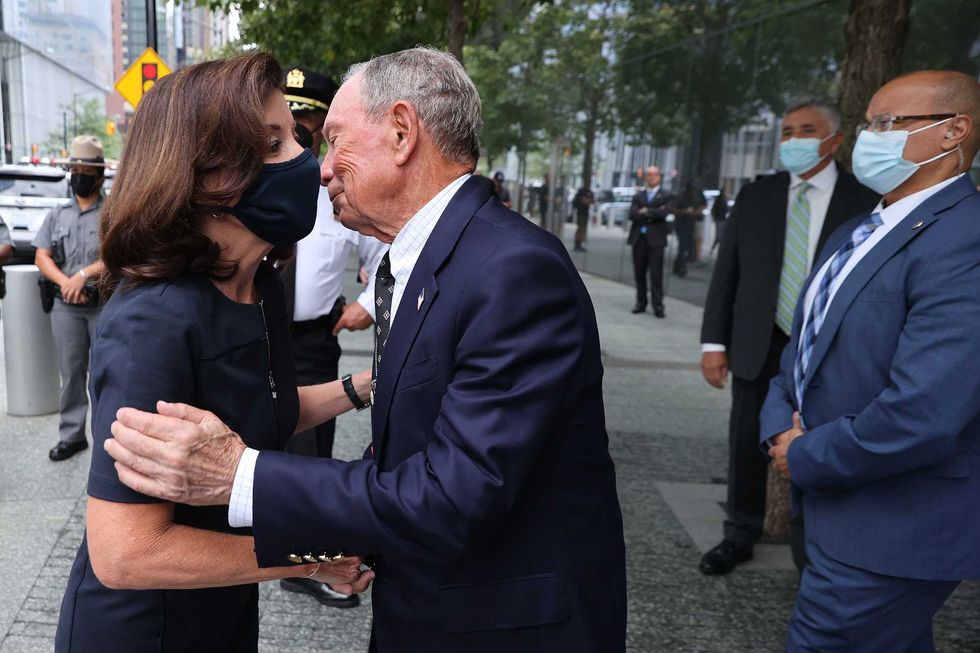 Gov. Kathy Hochul (L) is greeted by former Mayor Mike Bloomberg before they toured the 9/11 Memorial & Museum and laid flowers at the edge of the south memorial pool on September 08, 2021