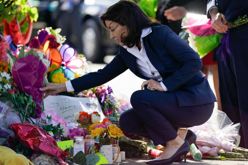 Gov. Kathy Hochul looks at a memorial at the scene of a shooting at a supermarket as she pays respects to the victims of Saturday