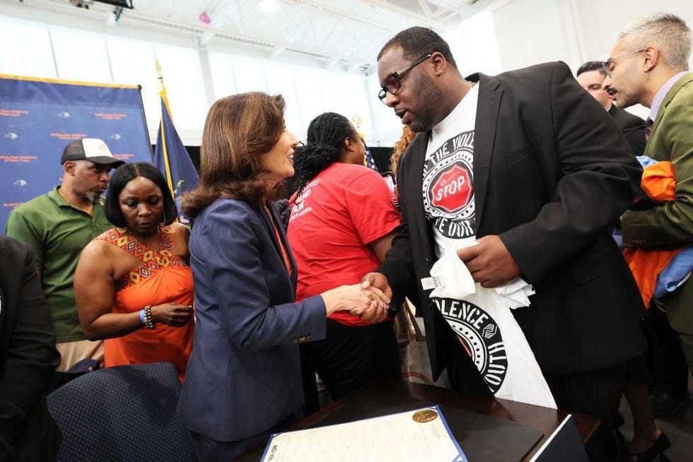 Gov. Kathy Hochul speaks with Paul Dunn, Gun and Violence Prevention Director at the Boys & Girls Club of Albany, after signing legislation during a bill signing ceremony at the Northeast Bronx YMCA on June 06, 2022 in New York City.Michael M. Santiago/Getty Images)