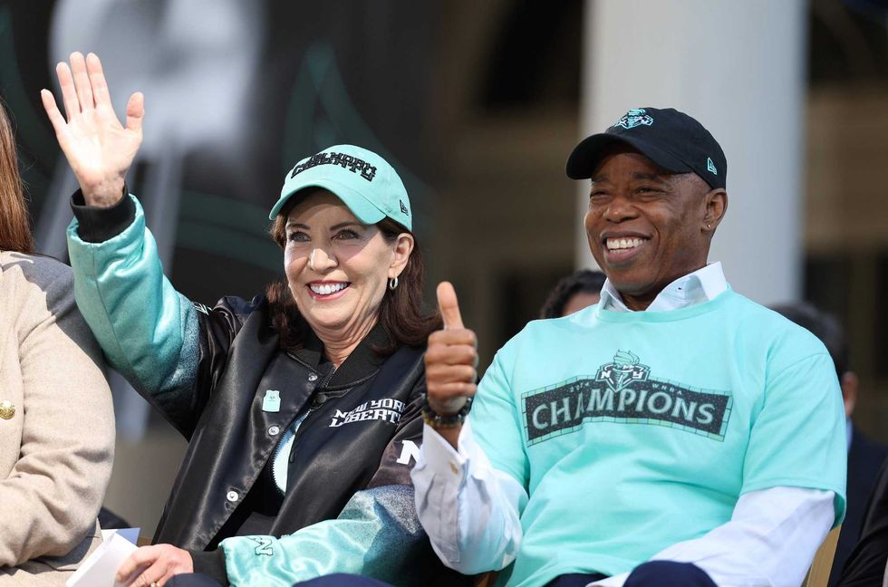 Governor of New York Kathy Hochul (L) and New York City Mayor Eric Adams react on stage during the New York Liberty Championship ticker tape parade celebrating winning the 2024 WNBA Finals on October 24, 2024