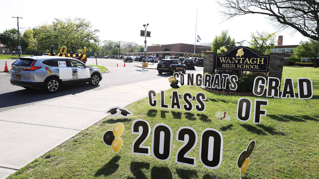 Graduating Seniors from Wantagh High School drive by the front of the school in a Class of 2020 Parade on May 15, 2020 in Wantagh, New York.