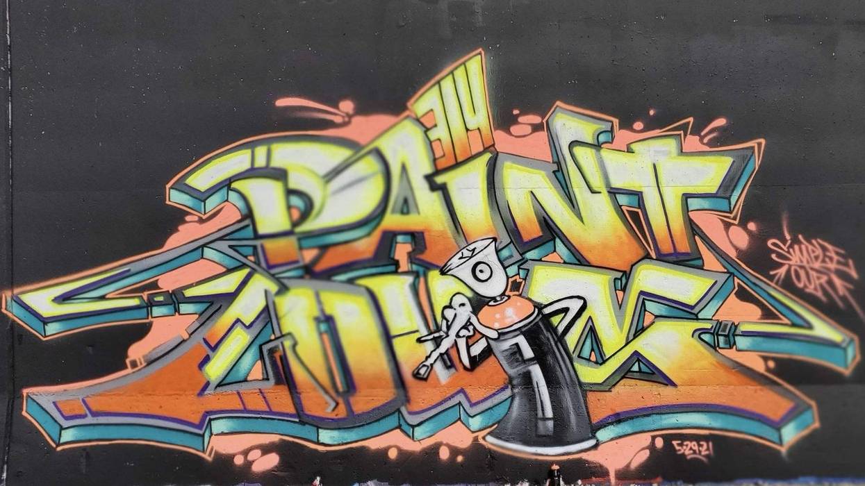 Graffiti that says "paint louis" in orange yellow and white outlined in blue on a black background with an anthropomorphic spray can in front