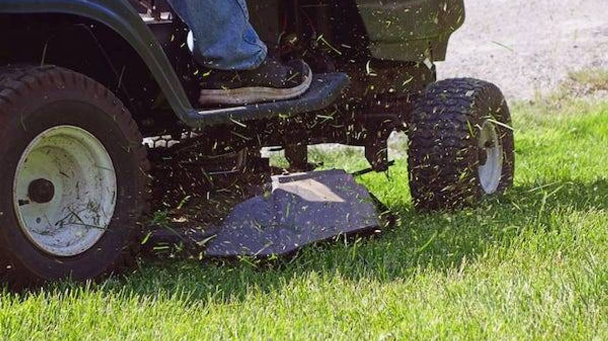 Grass flying from riding lawn mower