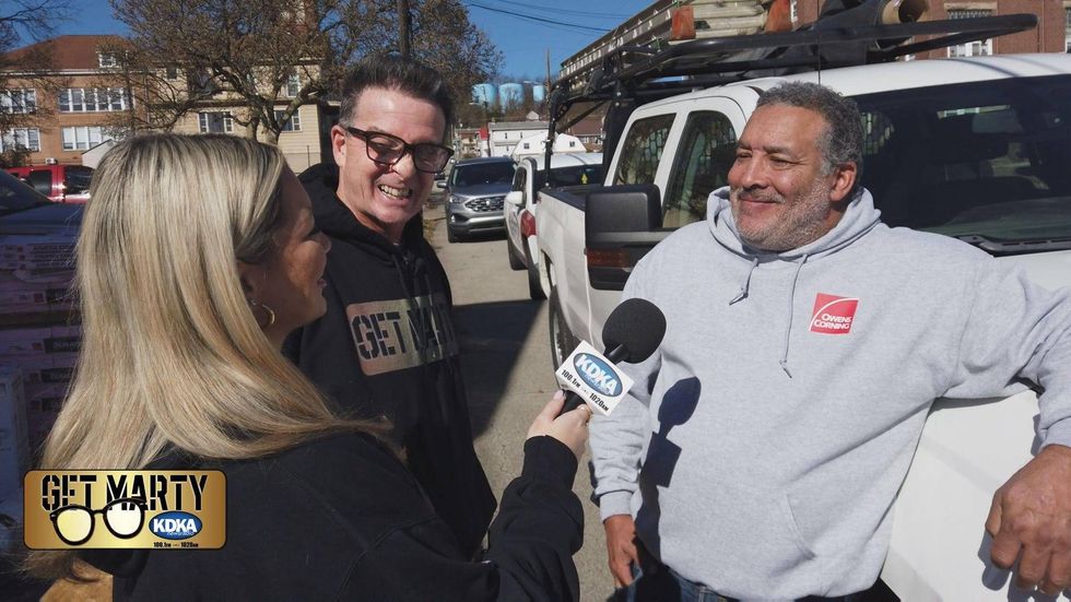 Grateful veteran Kenneth Snead talks to Marty Griffin and Arianna Bazzy while his new roof is being installed.