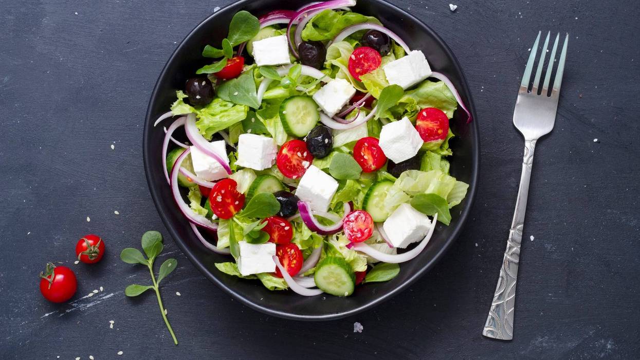 Greek salad with fresh cucumber, tomato, sweet pepper, lettuce, red onion, feta cheese and olives olive oil. Healthy food