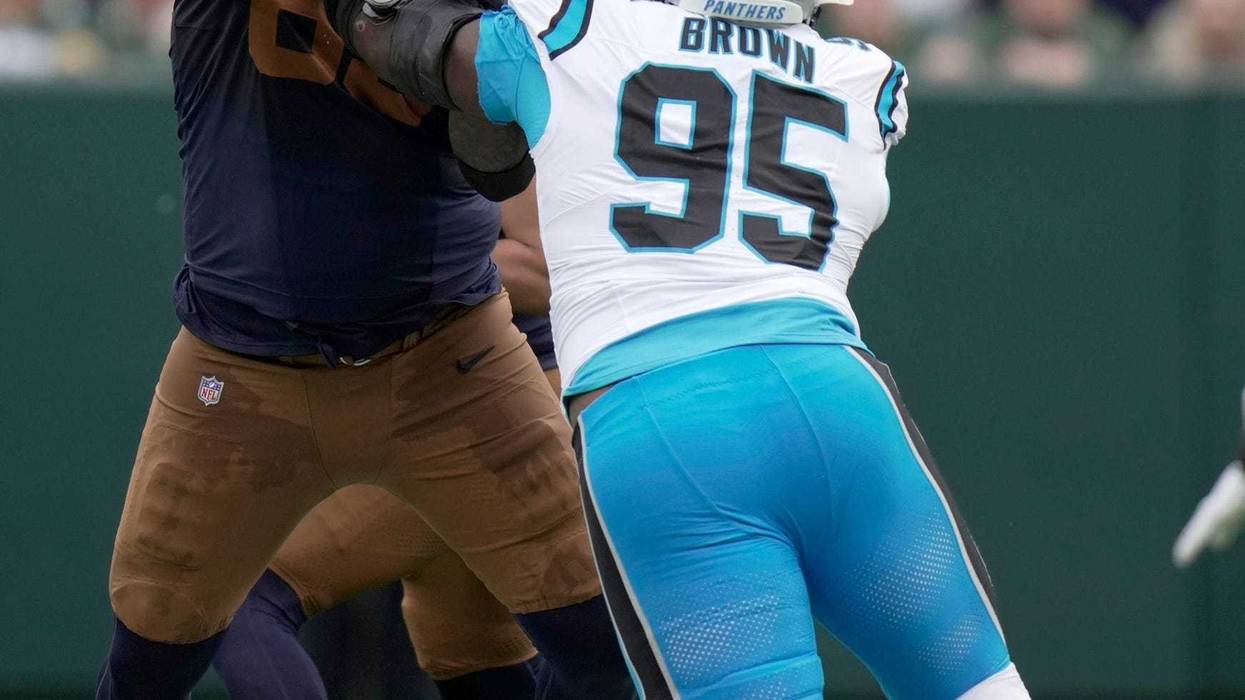Green Bay Packers guard Aaron Banks (65) blocks Carolina Panthers defensive end Derrick Brown (95) during the first quarter of their game Sunday, November 2, 2025 at Lambeau Field in Green Bay, Wisconsin.