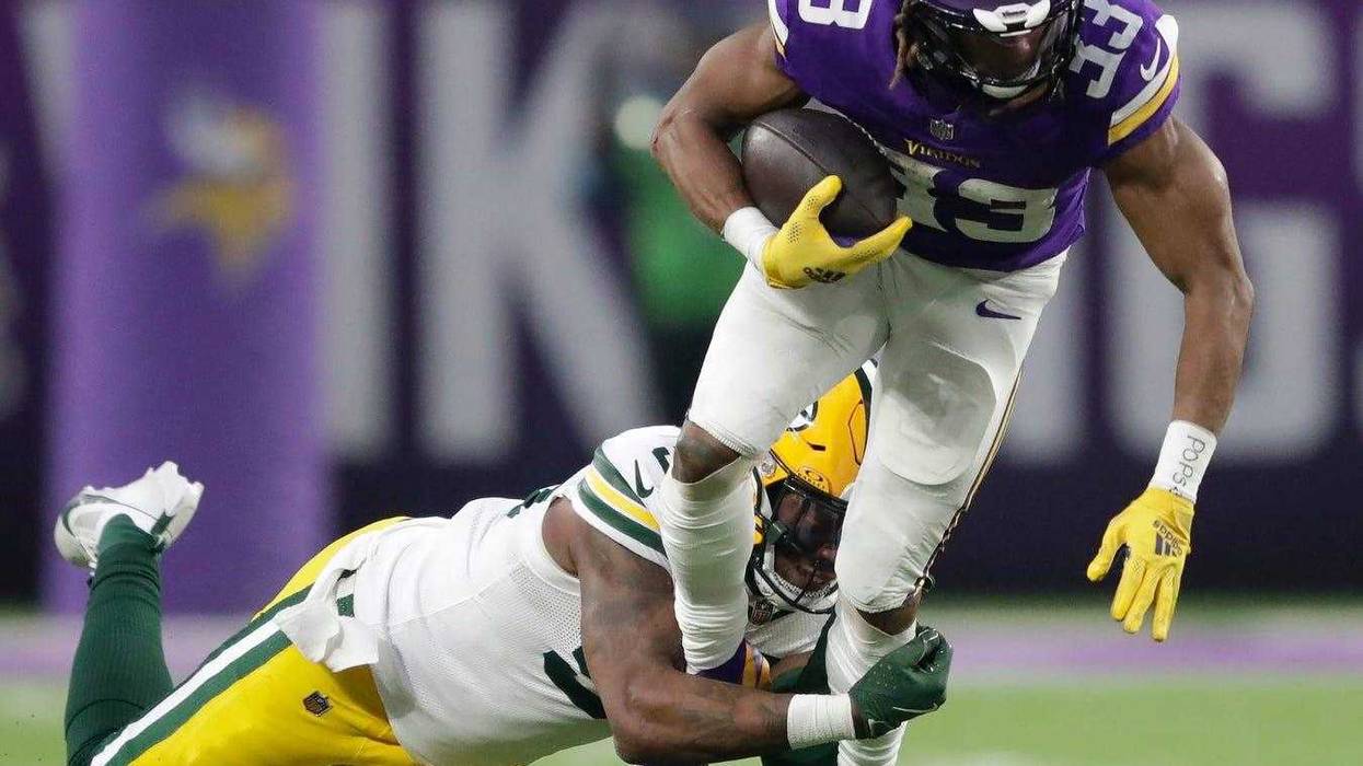 Green Bay Packers linebacker Edgerrin Cooper (56) tackles Minnesota Vikings running back Aaron Jones (33) in the second quarter during their football game Sunday, December 29, 2024, at U.S. Bank Stadium in Minneapolis, Minnesota.