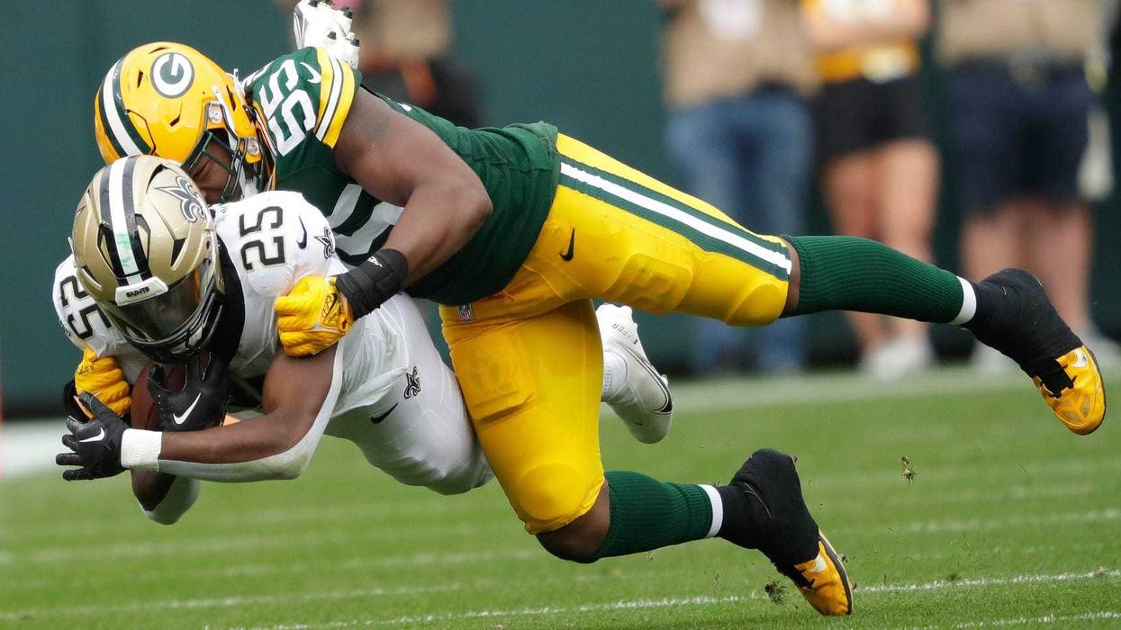 Green Bay Packers linebacker Kingsley Enagbare (55) tackles New Orleans Saints running back Kendre Miller (25) during their football game Sunday, September 24, 2023, at Lambeau Field in Green Bay, Wis.