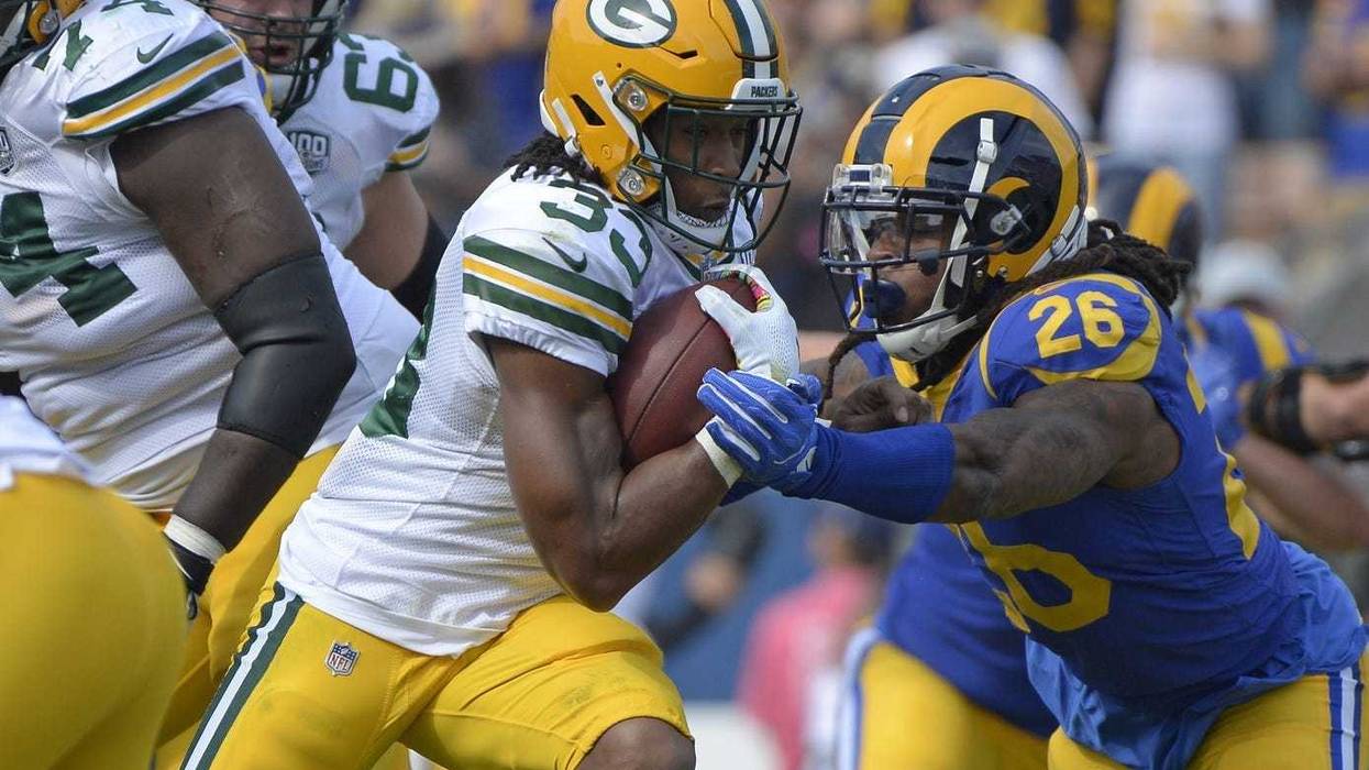 Green Bay Packers running back Aaron Jones (33) is defended by Los Angeles Rams linebacker Mark Barron (26)