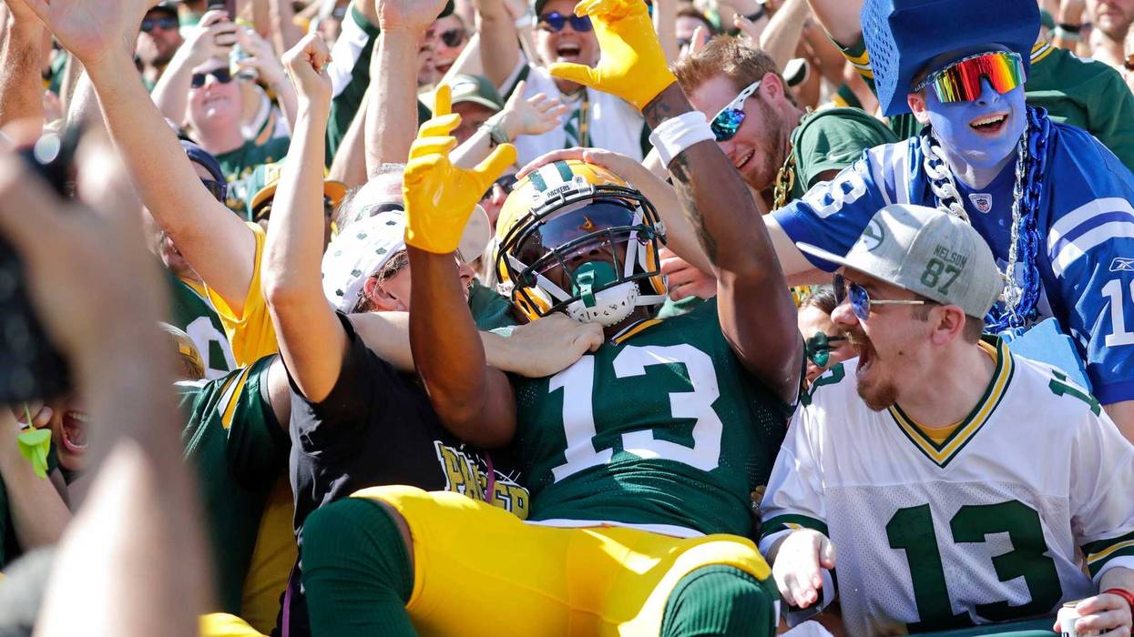 Green Bay Packers wide receiver Dontayvion Wicks (13) celebrates with fans on a Lambeau Leap after scoring a touchdown in the first quarter against the Indianapolis Colts during their football game Sunday, September 15, 2024, at Lambeau Field in Green Bay, Wisconsin.