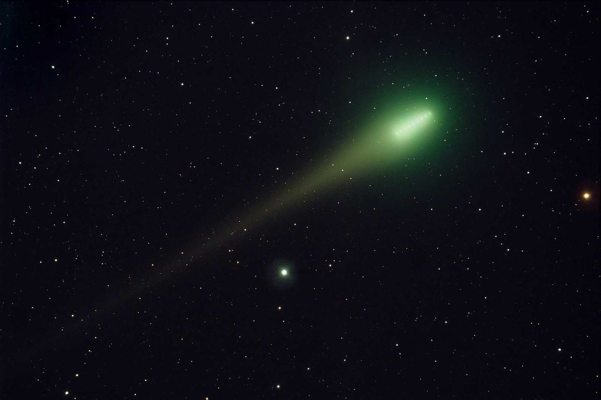 Green comet going through space.
