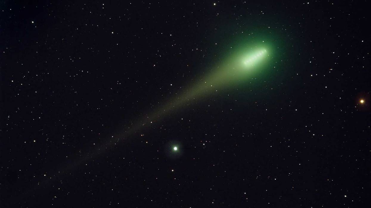 Green comet going through space.