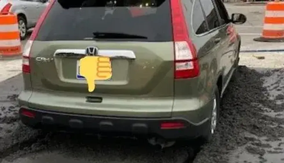 Green Honda in wet concrete