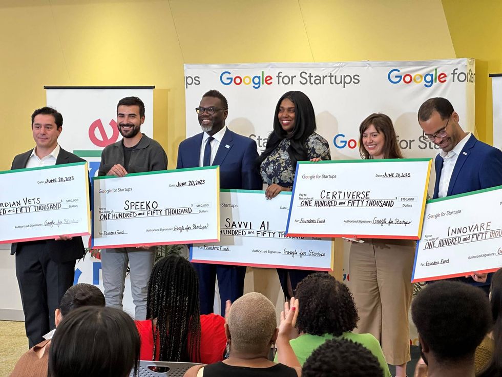 group holding oversized checks
