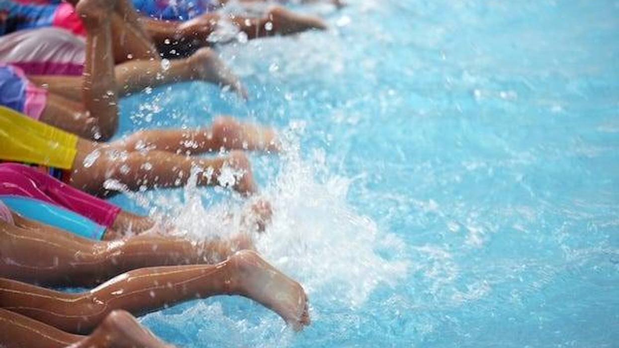 Group of children in a pool learning how to swim
