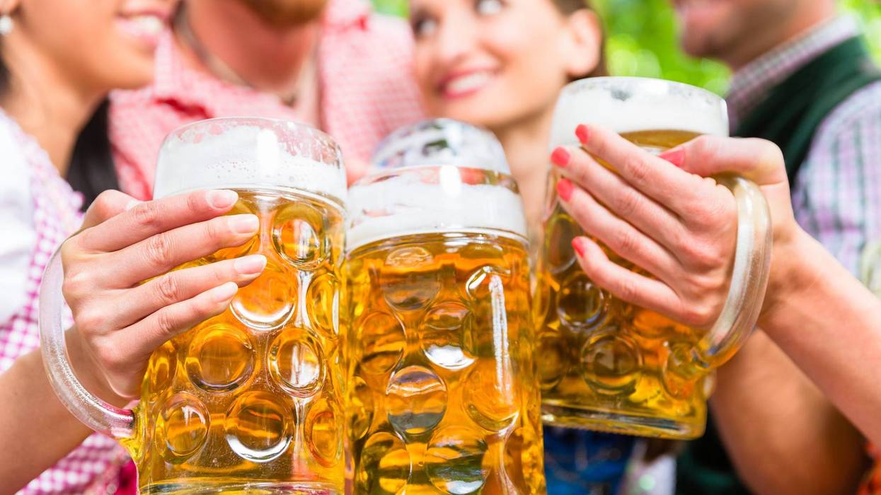 Group of friends holding steins and cheersing.