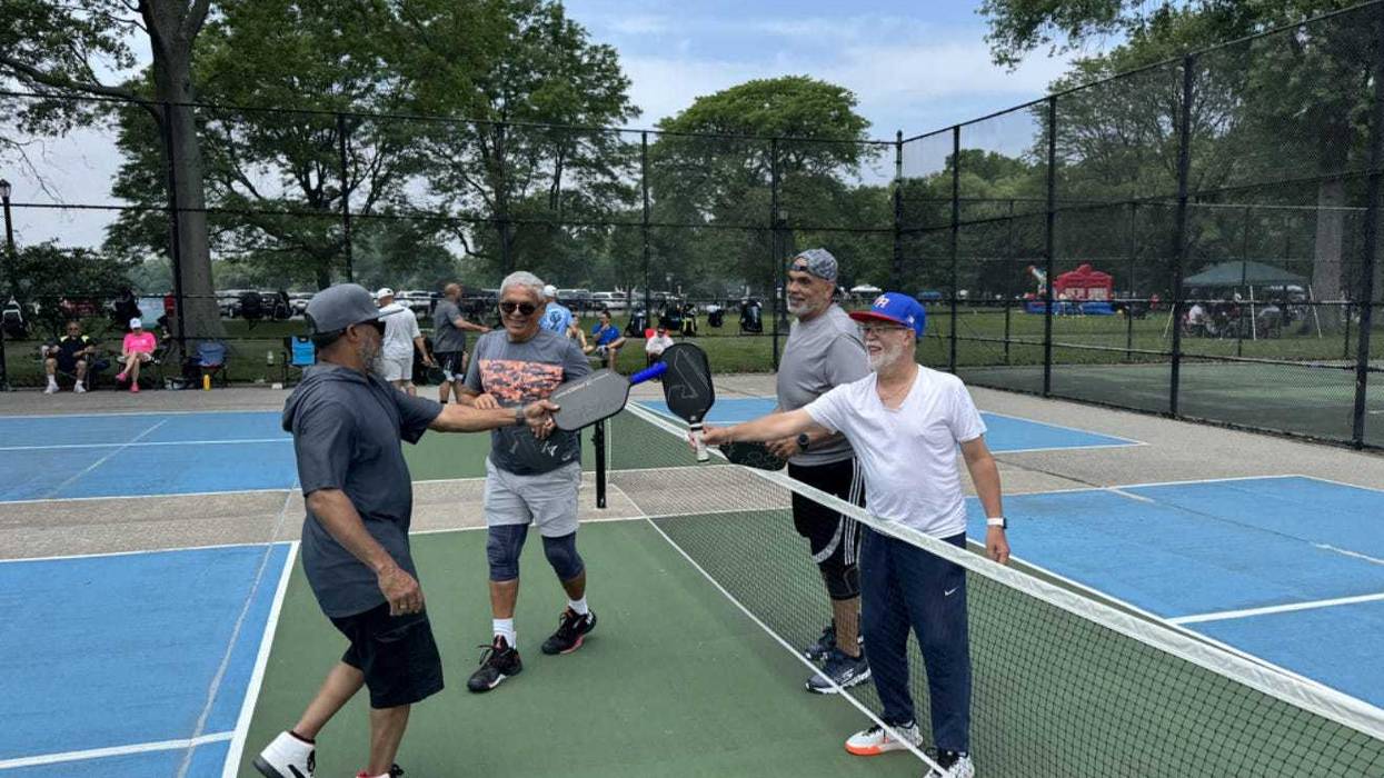 group of pickleballers shake hands at net