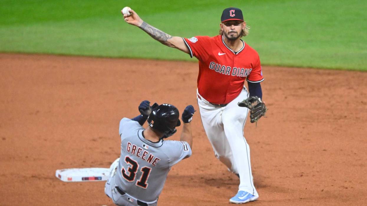 Guardians shortstop Gabriel Arias (13) turns a double play beside Detroit Tigers left fielder Riley Greene (31) in the second inning at Progressive Field