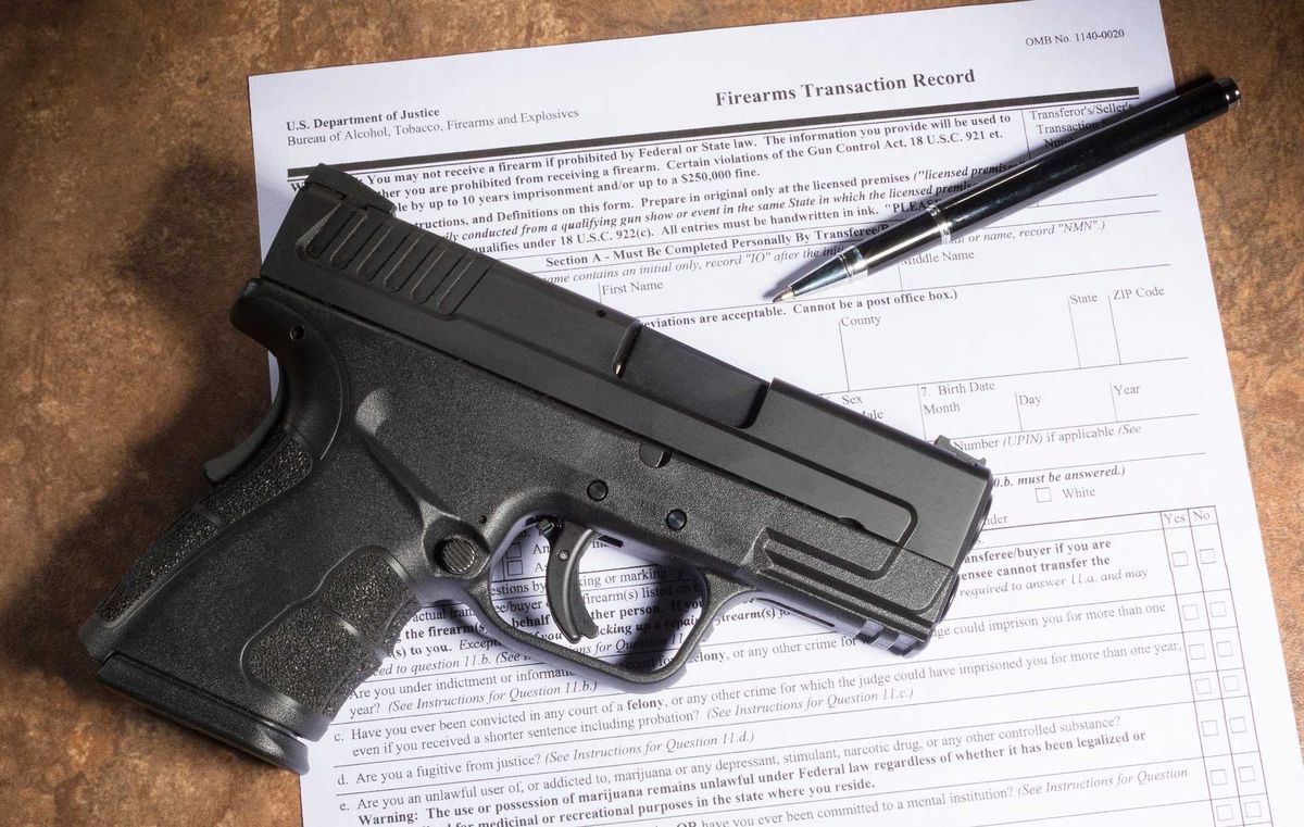 Gun buying paperwork and a firearm.