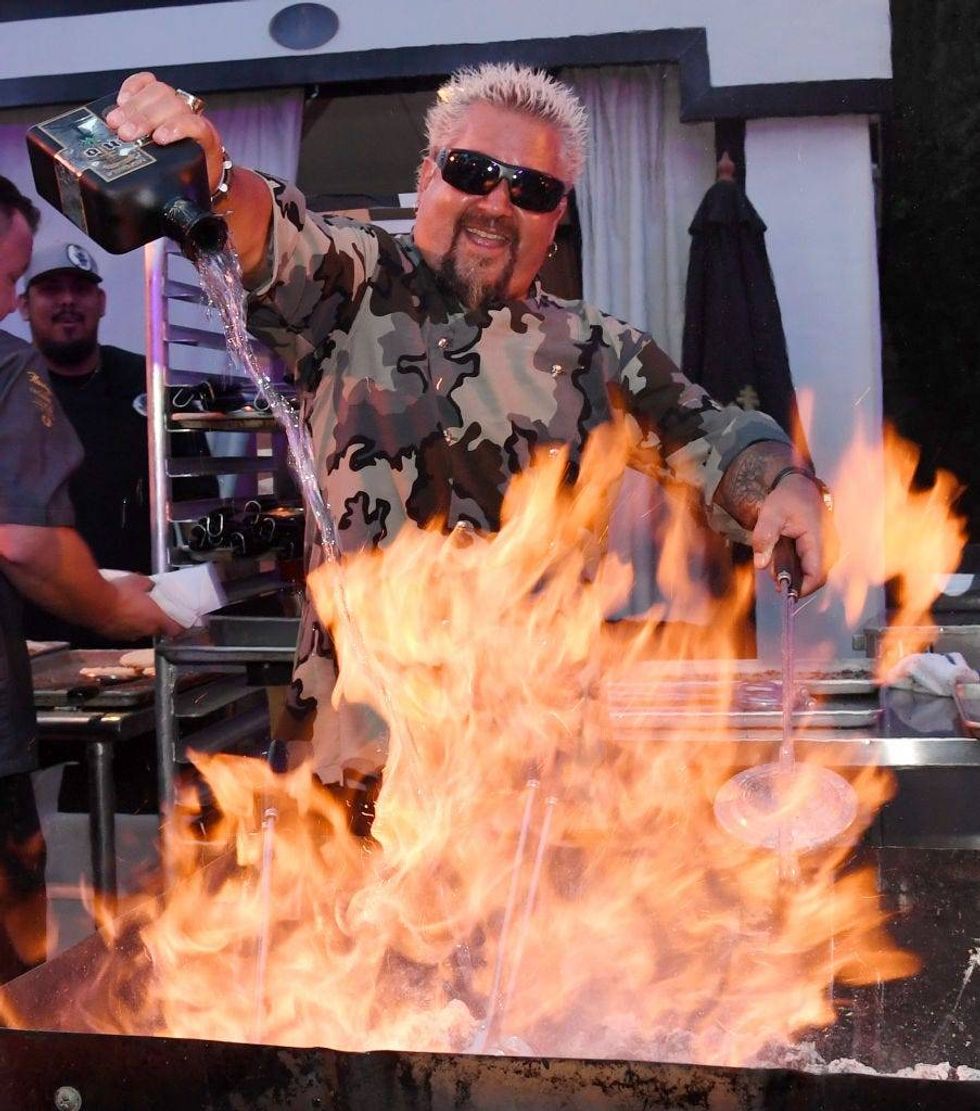 Guy Fieri prepares food using Santo Puro Mezquila at the Guy Fieri