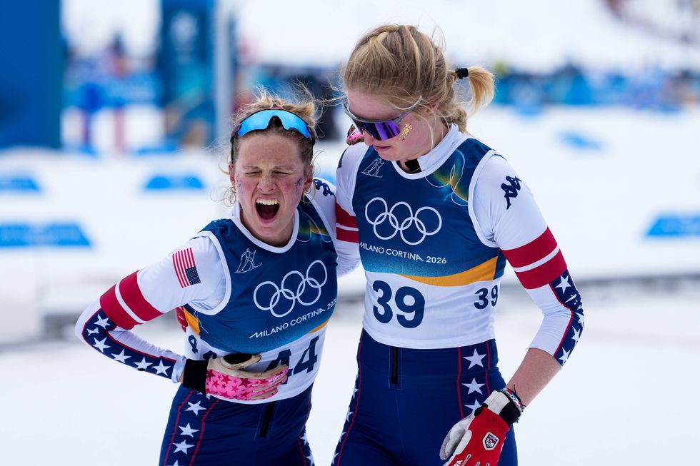 Hailey Swirbul (right) of Team United States, Jessie Diggins (left) of Team United States celebrate on day six of the Milano Cortina 2026 Winter Olympic games at Tesero Cross-Country Skiing Stadium on February 12, 2026 in Val di Fiemme, Italy. Diggins won bronze despite very painful bruised ribs in the demanding 10K race.