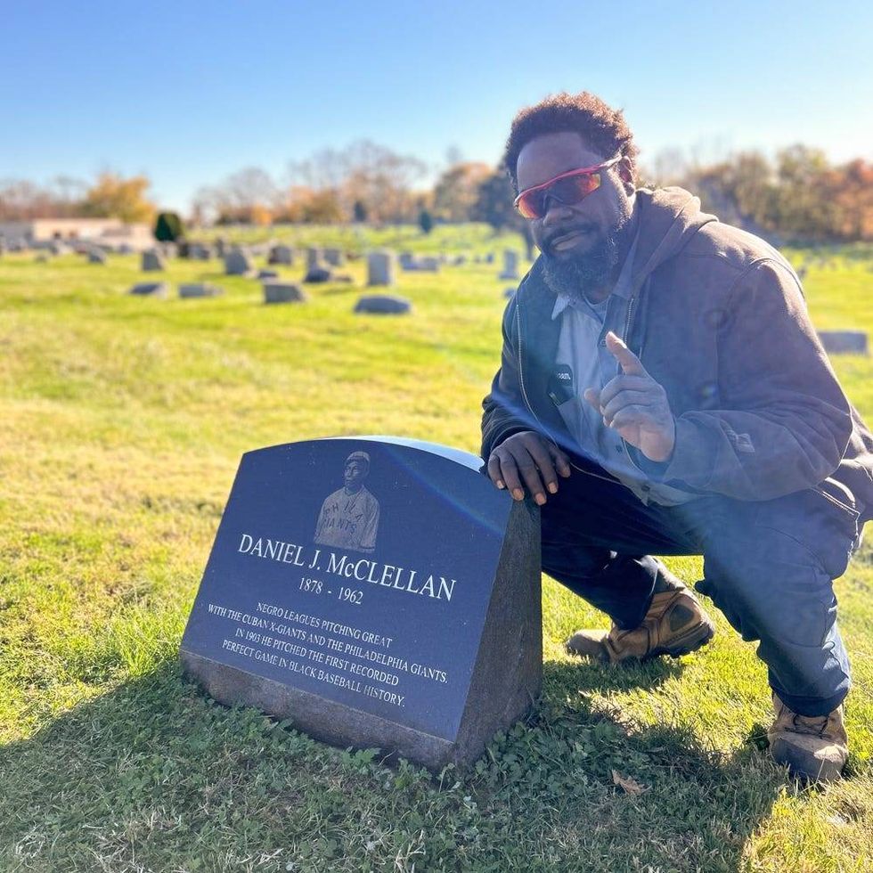 Hakeem Thomas Sr., superintendent of Eden Cemetery in Collingdale, Pa., poses by the headstone of legendary Negro Leagues pitcher Daniel McClellan.