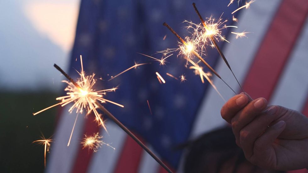 Hand holding sparkler for Fourth of July