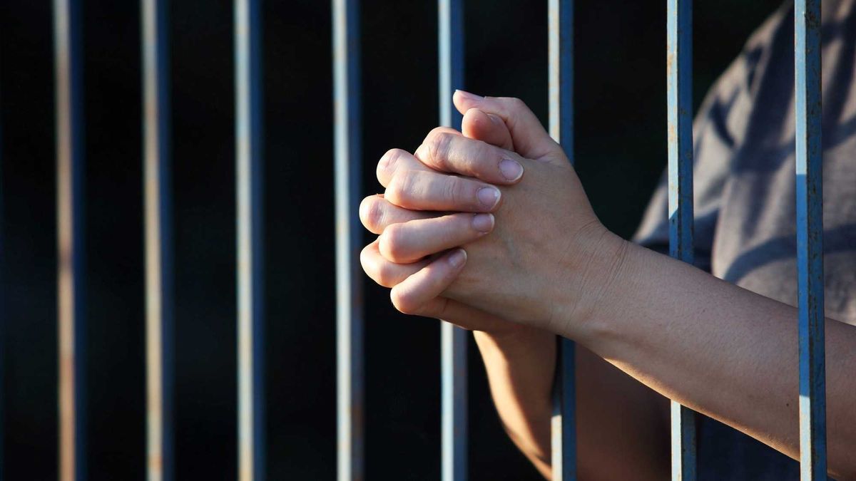hand praying in jail