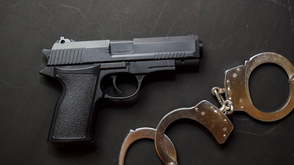 Handcuffs and Gun isolated on black background. Justice and law concept