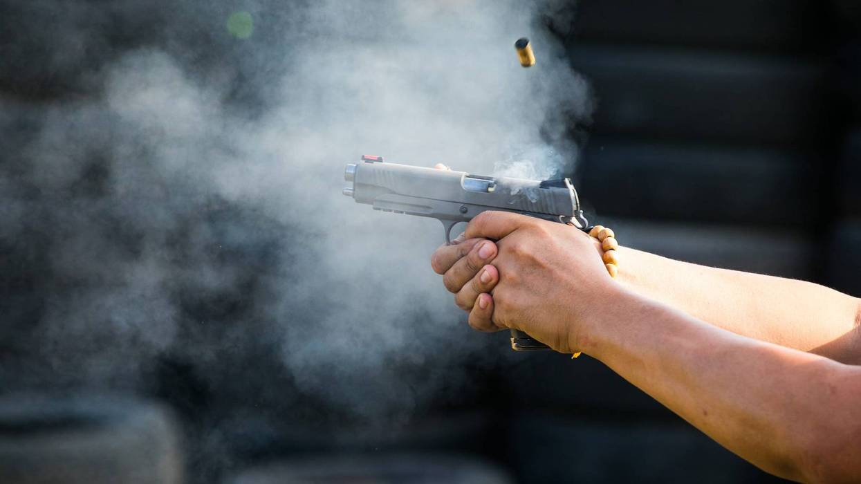 Hands firing a handgun.