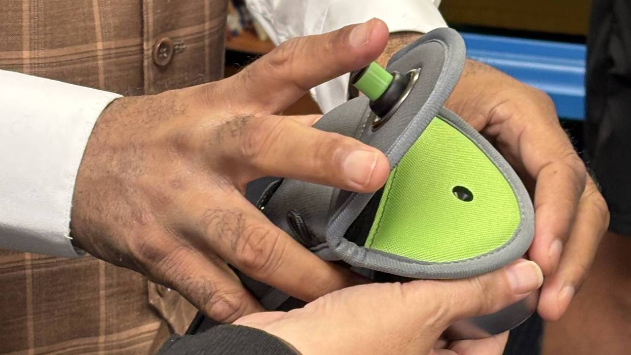 Hands hold a locking Yondr pouch for cell phone storage.