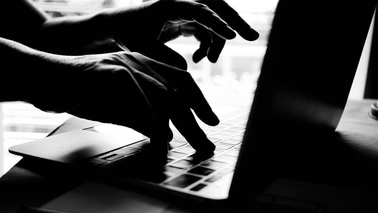 Hands of anonymous hackers typing code on keyboard of laptop for remotely reach and receiving personal information online networking, Internet Crime Payment Security Concept, Silhouette black white