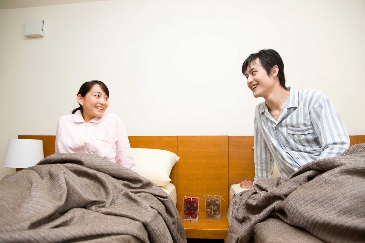 Happy couple in separate beds