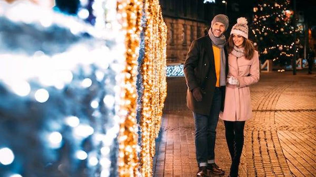 Happy couple walks on a street decorated for Christmas