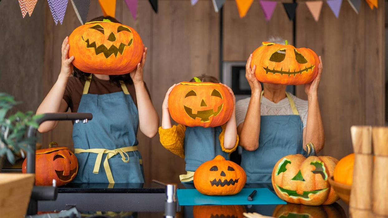 Happy family preparing for Halloween. Mother, grandmother and child carving pumpkins at home