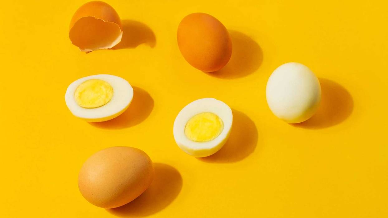 Hard boiled eggs and brown shells on a clean yellow background.