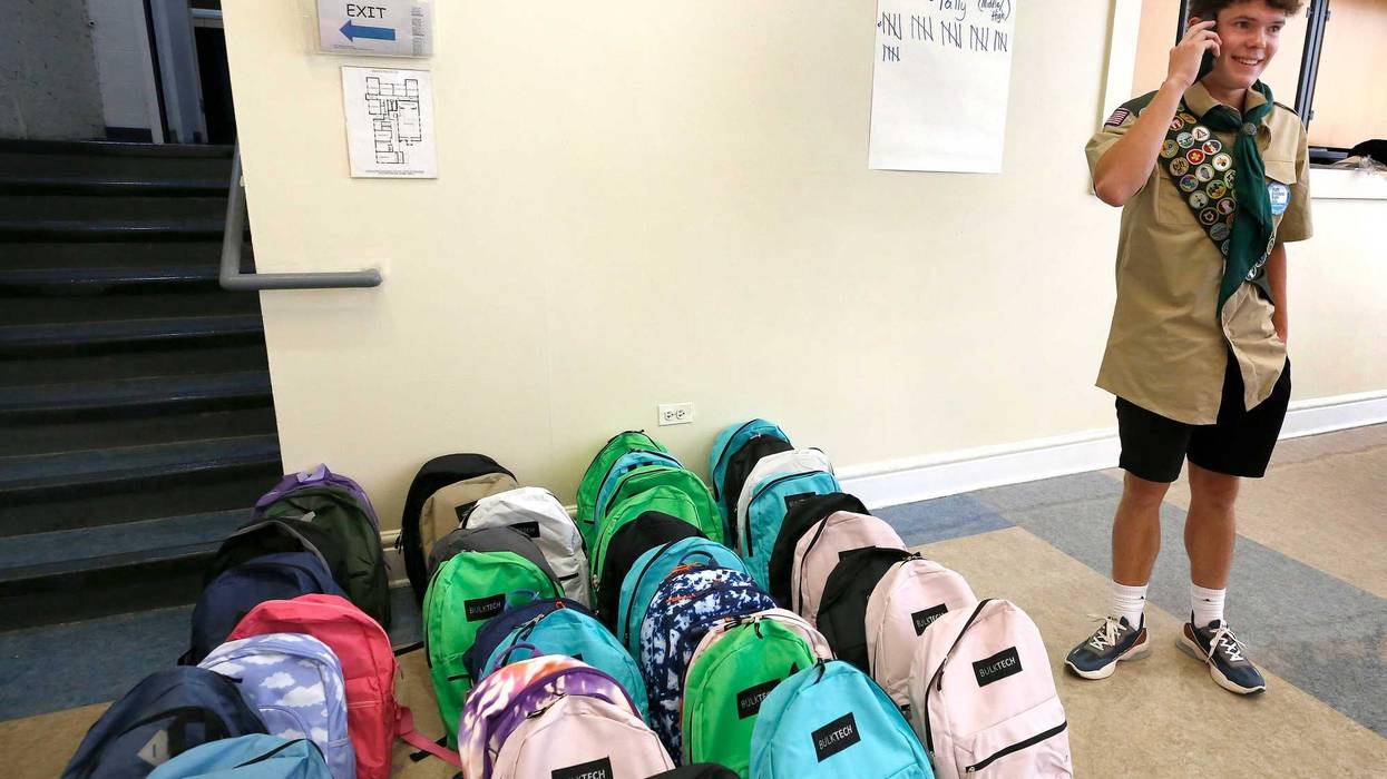 Harrison Mellon stands next to dozens of backpacks. The 16-year-old led a donation effort in Chicago to help provide migrant children with supplies for the upcoming school year.