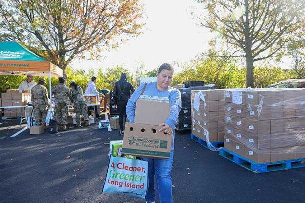 Hauppauge, N.Y.: Unemployed federal worker Rose Voskinarin, 52-years-old of Huntington Station, New York, carries food she received at the Center for Community Engagement in Hauppauge, Oct. 23, 2025.