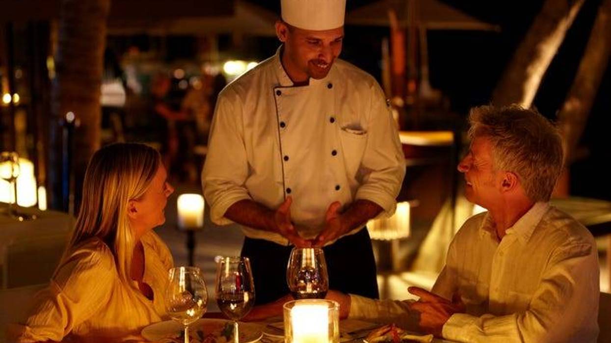 Head chef and a couple share a friendly conversation while at his restaurant
