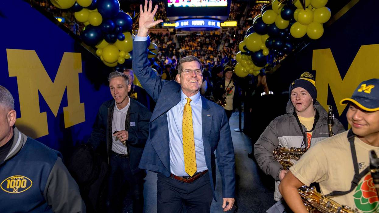 Head coach Jim Harbaugh of the Michigan Wolverines waves to fans after the Michigan Wolverines football National Championship celebration
