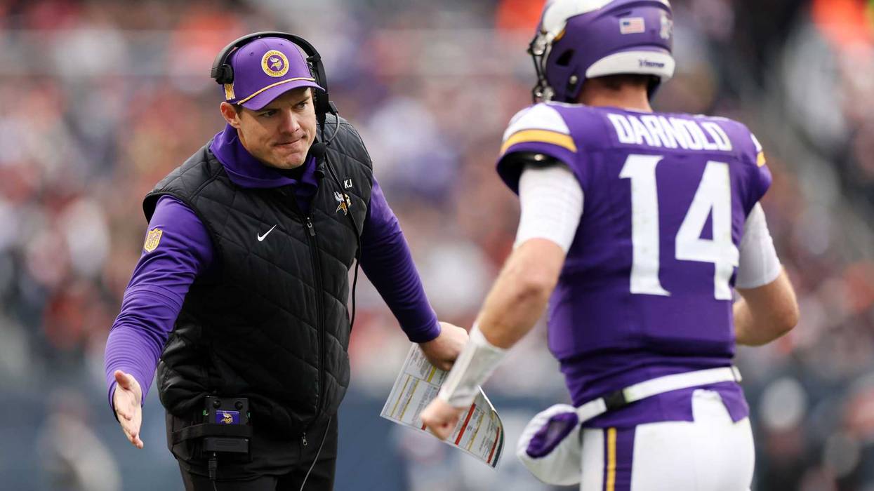 Head coach Kevin O'Connell of the Minnesota Vikings celebrates with Sam Darnold #14 after a touchdown during the third quarter against the Chicago Bears at Soldier Field on November 24, 2024 in Chicago, Illinois.