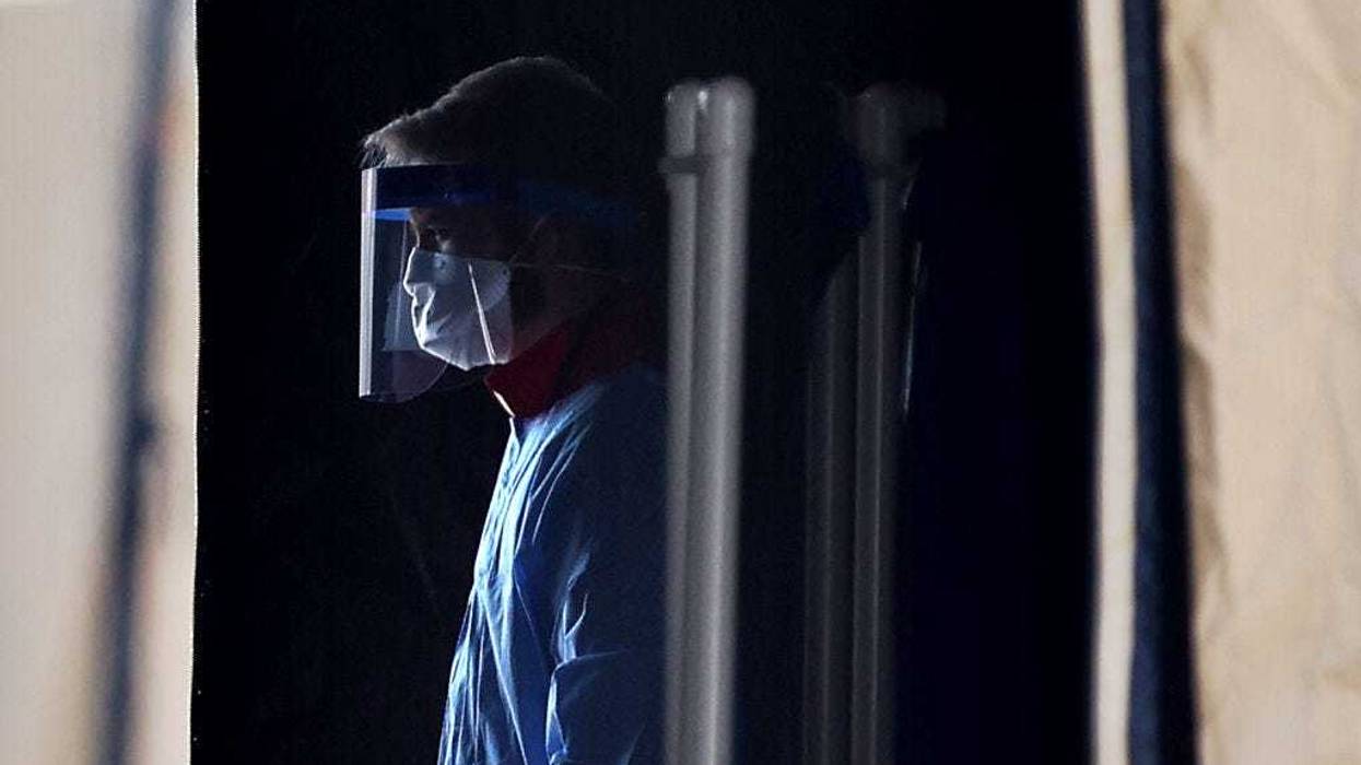 Healthcare professionals prepare to screen people for the coronavirus at a testing site erected by the Maryland National Guard in a parking lot at FedEx Field March 30, 2020 in Landover, Maryland.