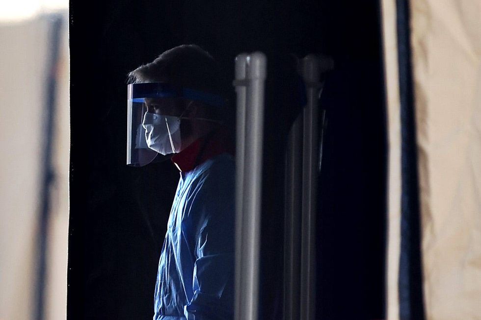Healthcare professionals prepare to screen people for the coronavirus at a testing site erected by the Maryland National Guard in a parking lot at FedEx Field March 30, 2020 in Landover, Maryland.