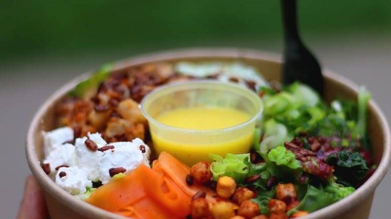 Healthy salad with various vegetables, chickpeas, feta cheese and dressing