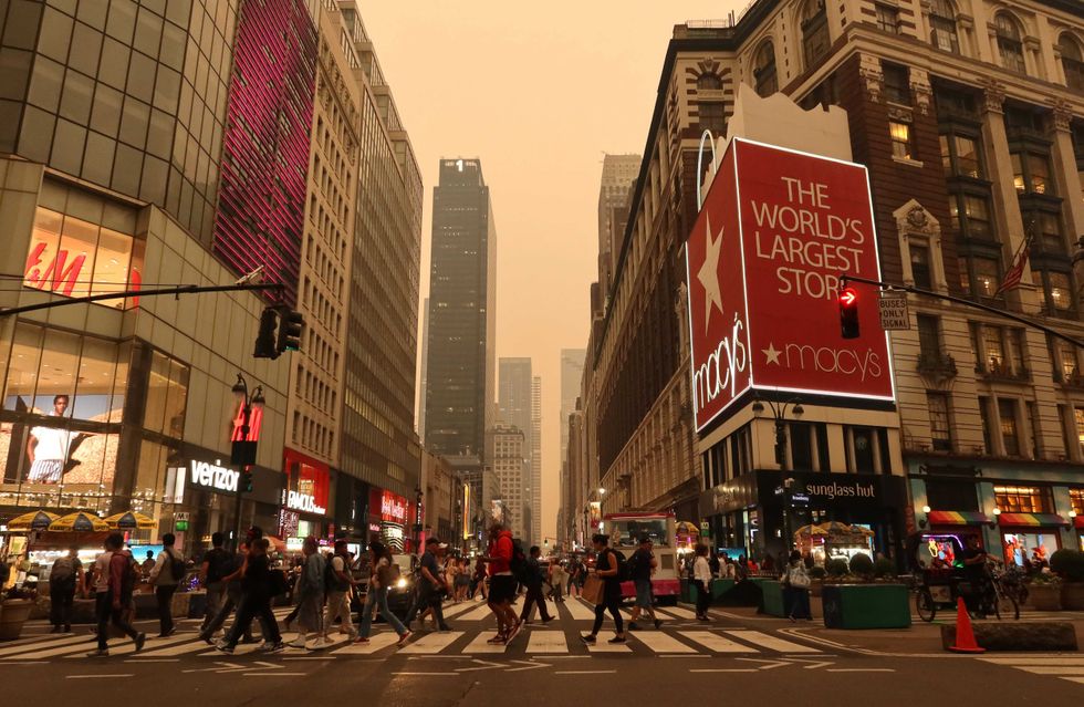 Heavy smoke fills the air as people cross 34th Street in Herald Square on June 6, 2023, in New York City